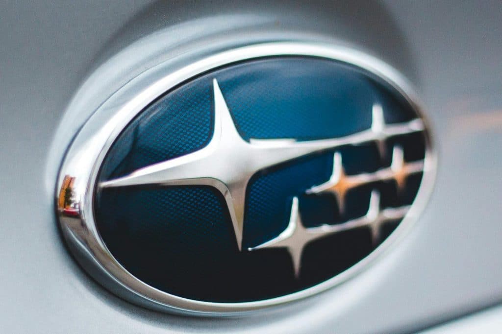 pexels-photo-12920610-12920610 Detailed image of a Subaru emblem on a silver car, showcasing design and branding.