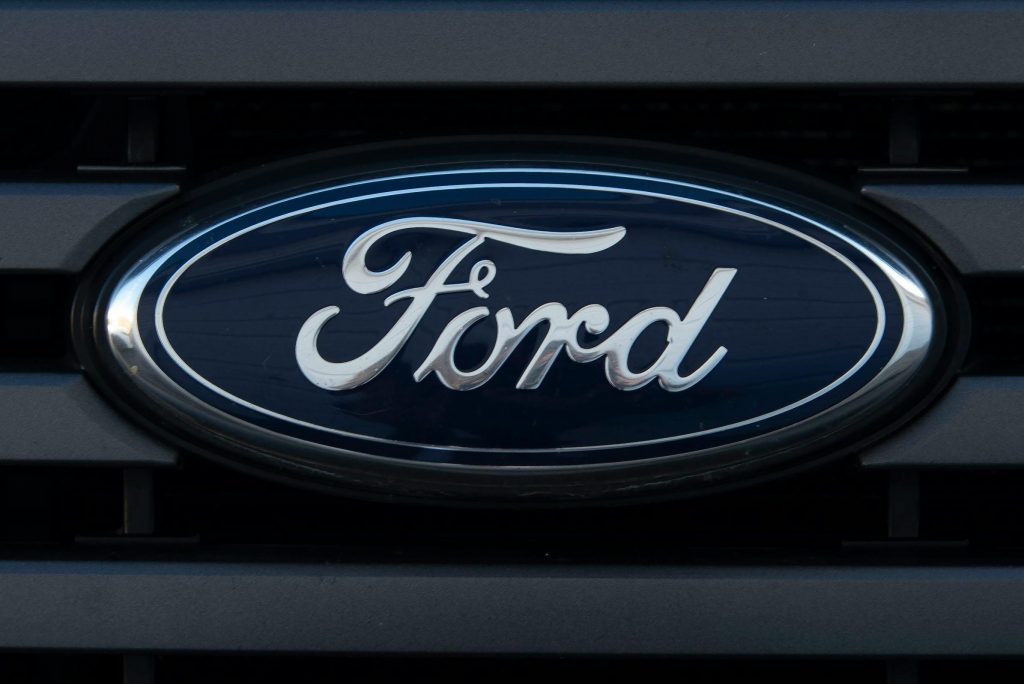 pexels-photo-3323202-3323202 Detailed view of a Ford emblem mounted on a vehicle grille, showcasing modern design.